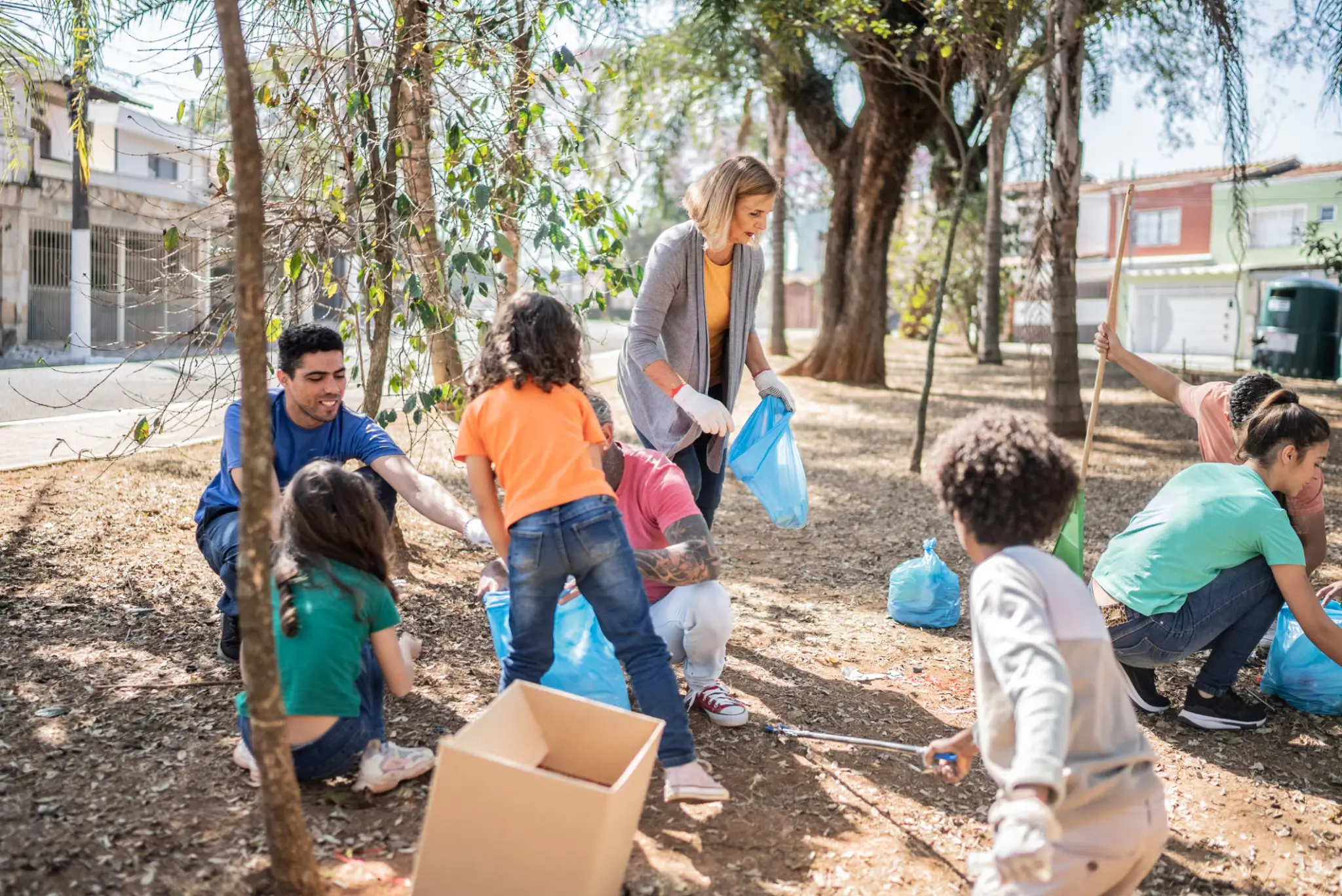 Children and adults cleaning park together.