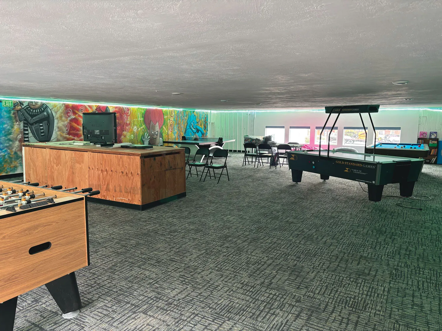 Game room with foosball and pool tables.