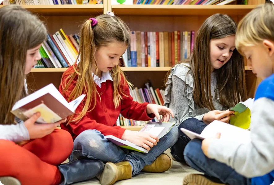 Children reading books in a library setting.